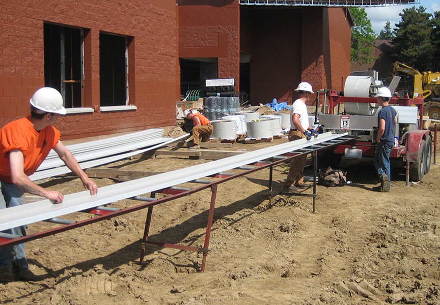 portable rollforming machine with panel coming out of machine on job site