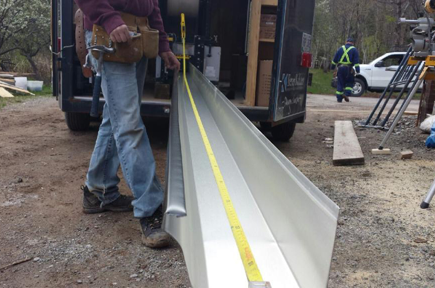 portable gutter machine inside truck with finished gutter coming out