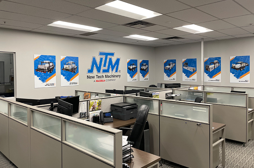 office space with NTM logo on wall and posters of portable rollforming machines