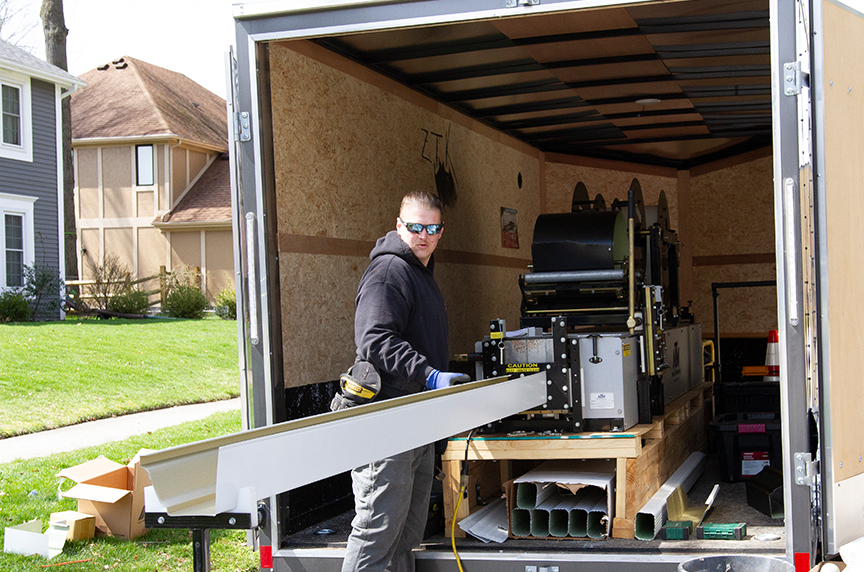 man operating a combo gutter machine in trailer