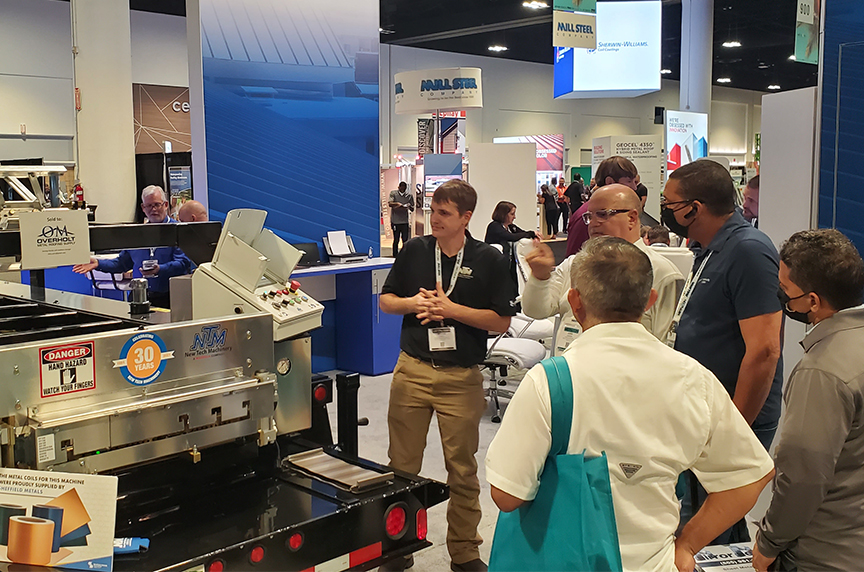 NTM service tech demonstrating a portable roof panel machine to show attendees