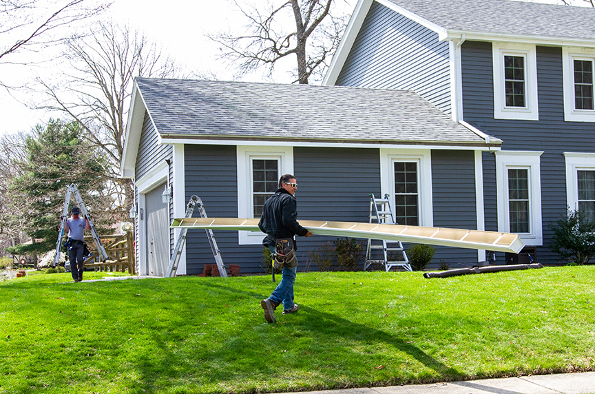 white gutter being carried to install on house