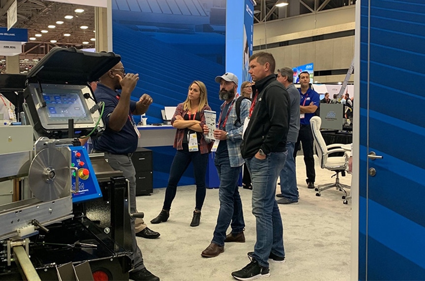 NTM service technician talking to attendees at an industry trade show