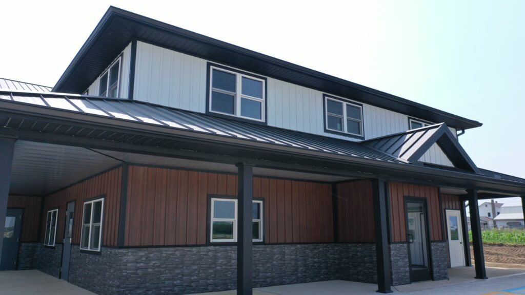 Office building with white metal board and batten on the second floor and metal wood print board and batten on the first floor.