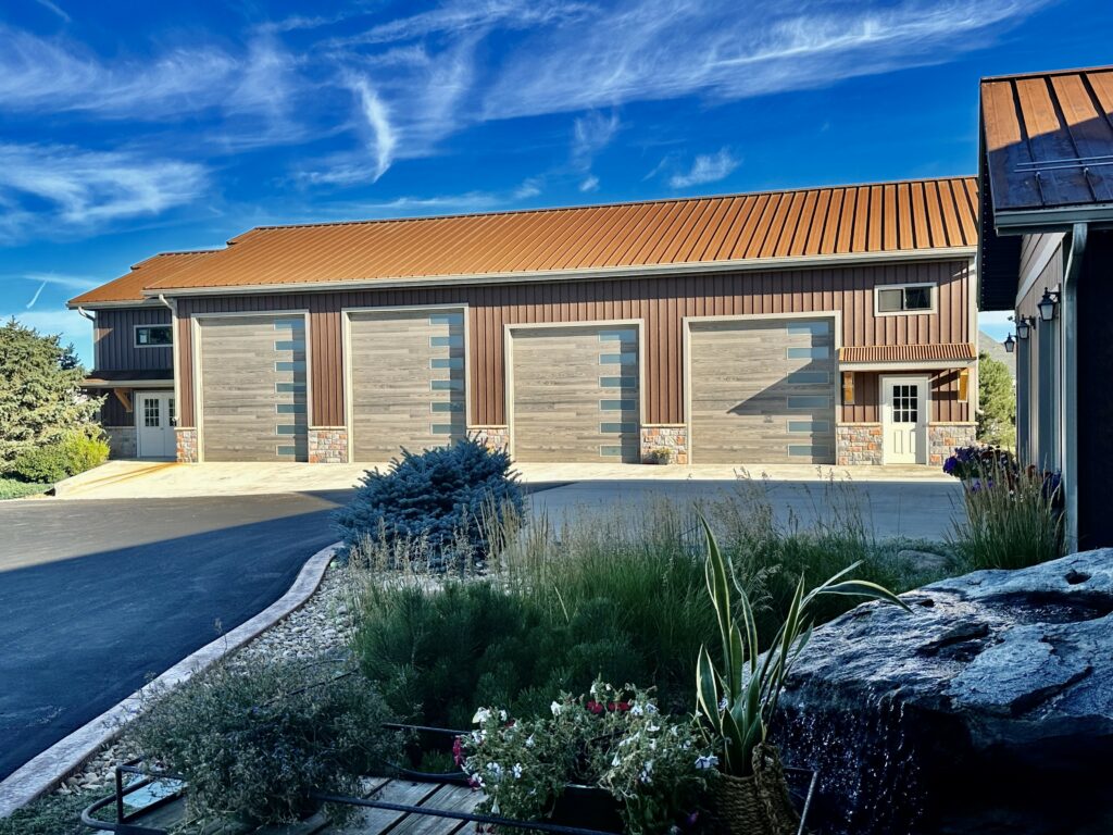 Barndominium with large decorative garage doors and cactus garden.