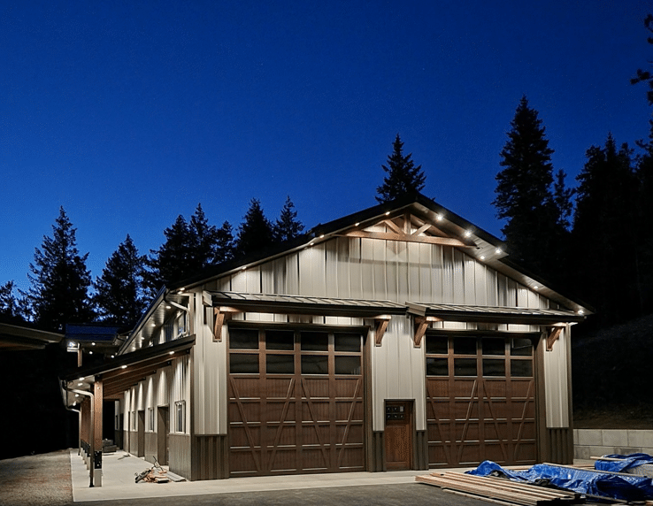 A barndominium at night with large barn-style garage doors.