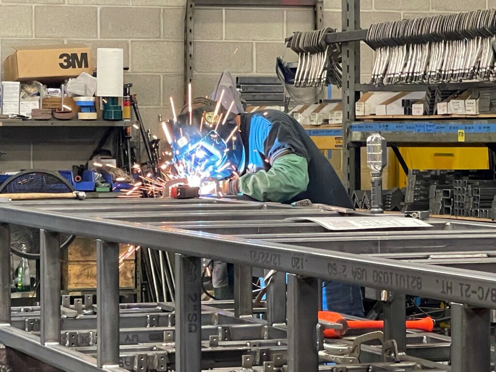 Welder welding a machine frame.