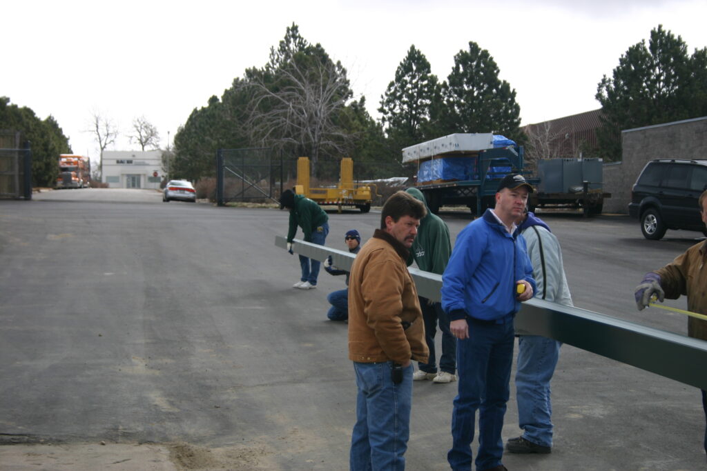 Box gutter forming on job site with workers holding it up.