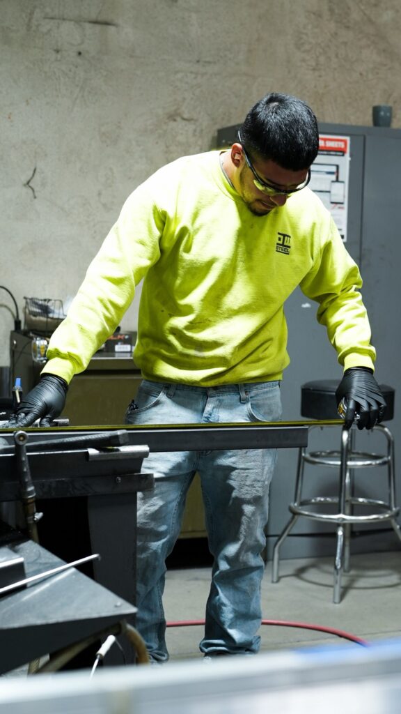 NTM production technician on the Aurora shop floor, assembling a rollforming machine.