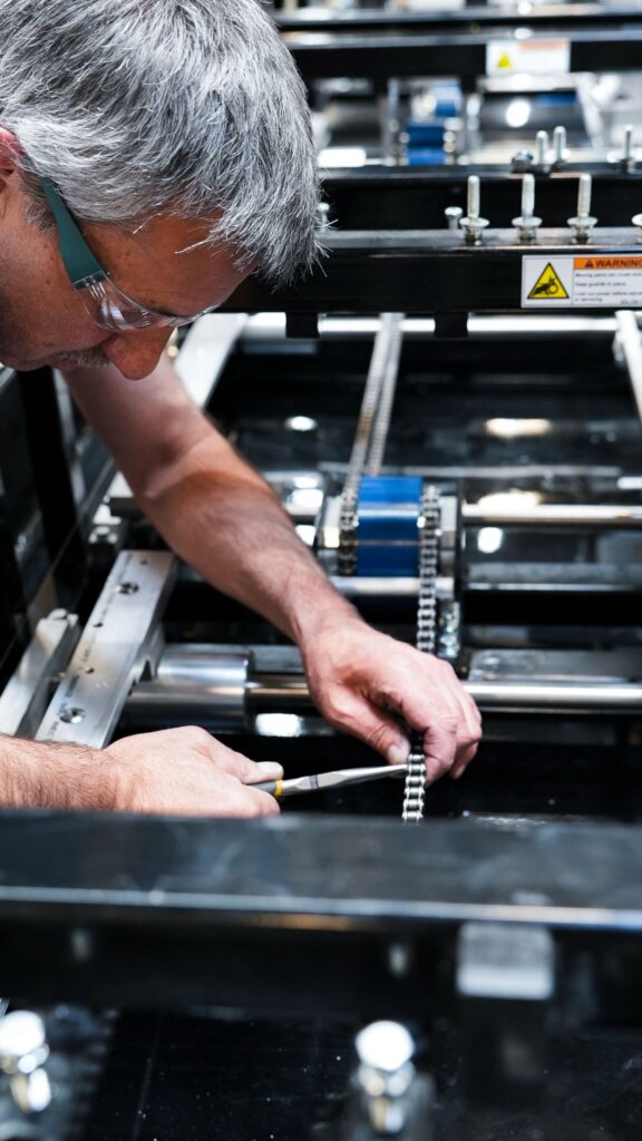 NTM service technician inspecting a rollforming machine in the field.